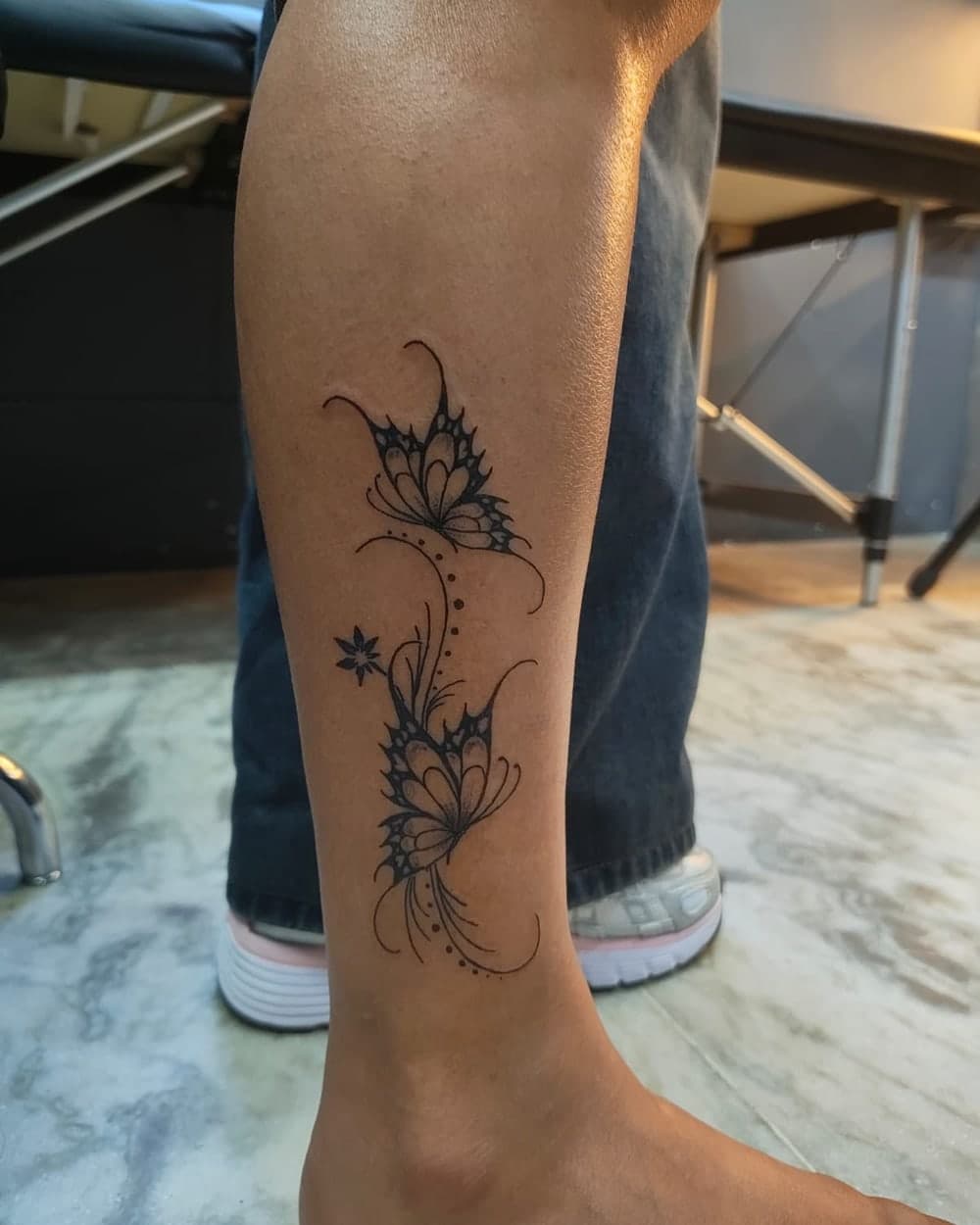 Delicate single-needle botanical fine line tattoo along the ribs