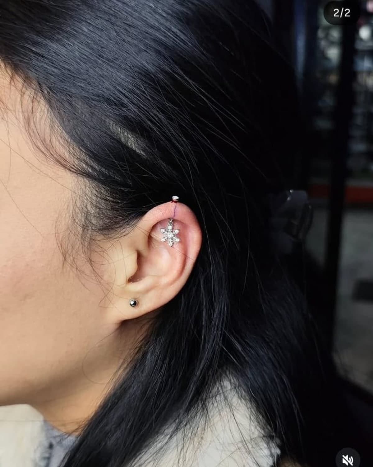 Helix piercing with a small floral charm