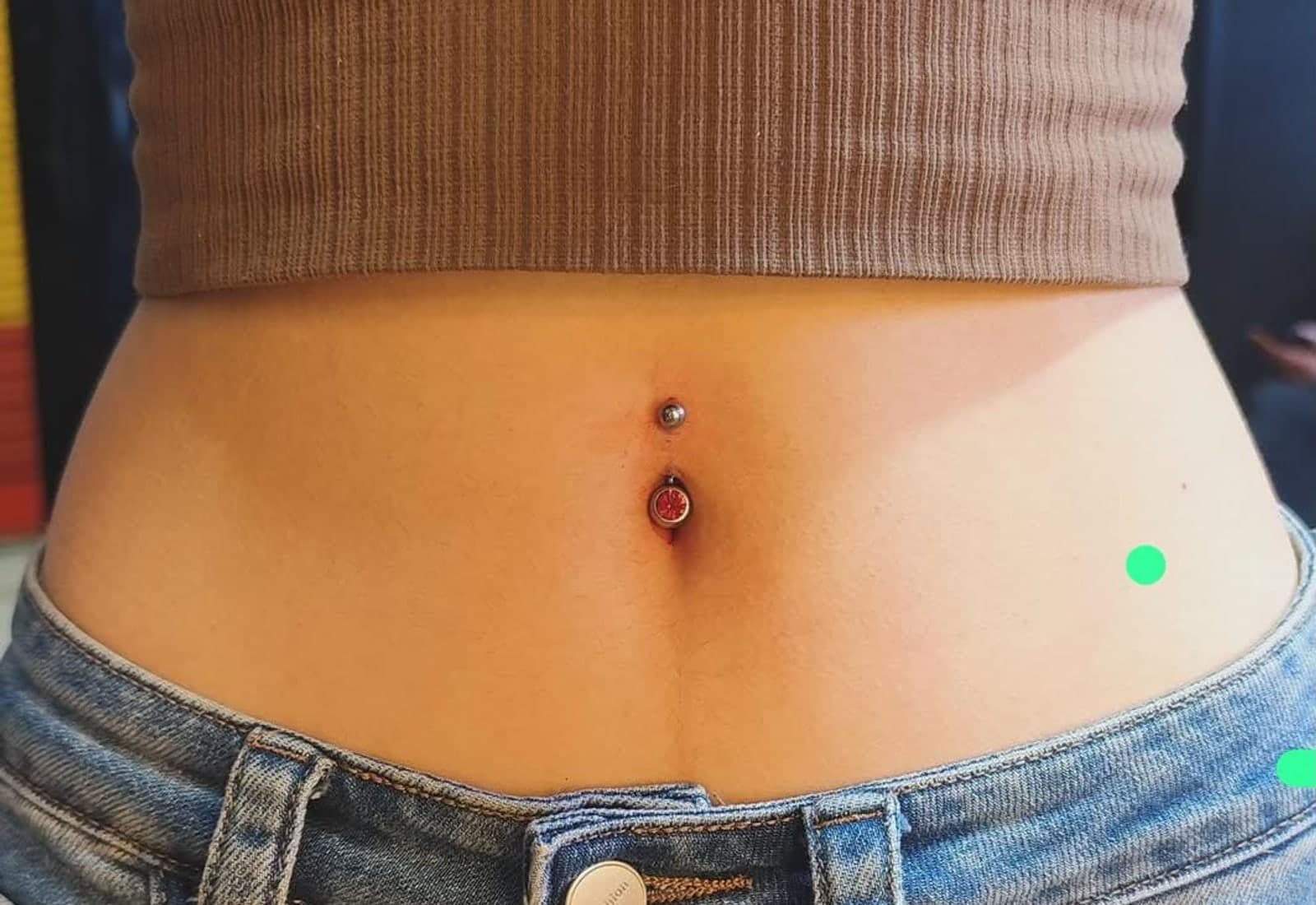 Healed navel piercing with a gemstone bar