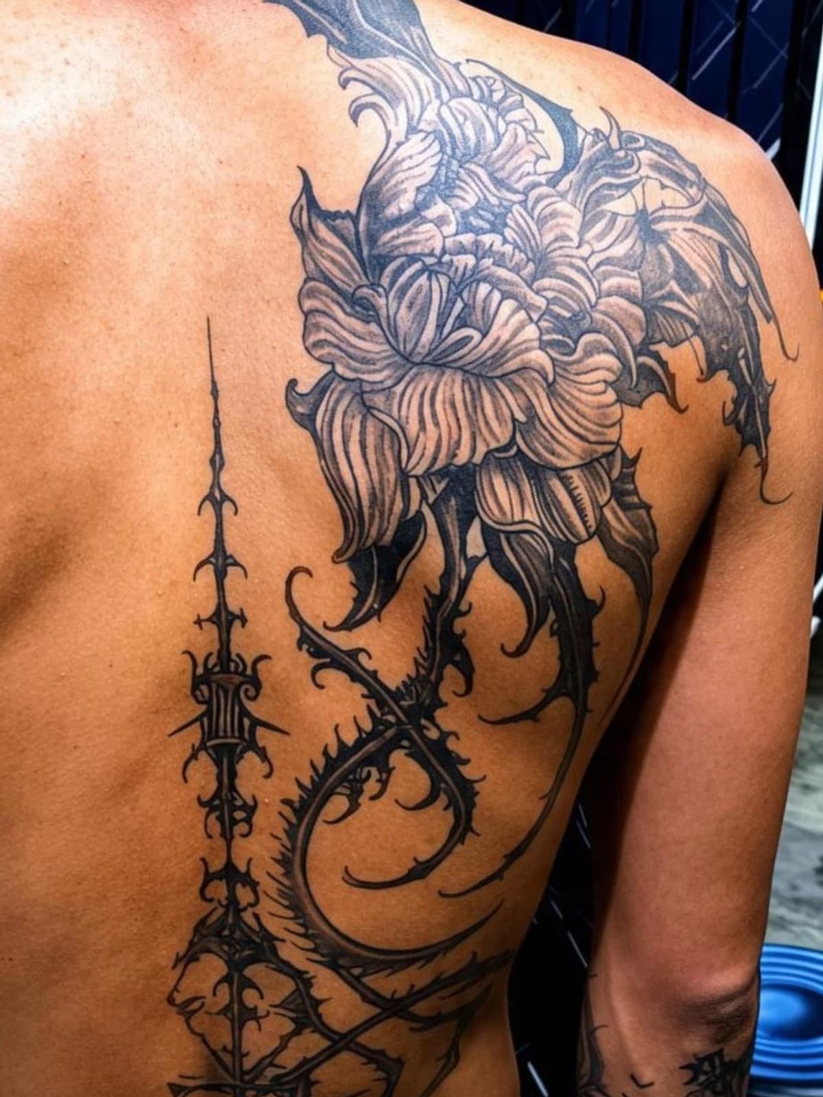 Dark ornamental floral back piece with thorned linework